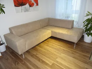 Modern bézs sarokülő fém lábakon, világos nappaliban