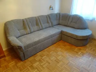 Szürkéskék sarokülő parkettás szobában